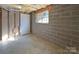 Unfinished basement area with concrete walls, utility door, and natural light window at 9530 Driftwood Ct, Hickory, NC 28601