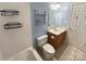 Cozy bathroom with a tub, commode, wood vanity, and functional wall storage at 9530 Driftwood Ct, Hickory, NC 28601