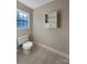 Powder room with toilet, window, and above toilet shelving at 9530 Driftwood Ct, Hickory, NC 28601