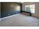 A spacious bedroom featuring carpet flooring, a large window, and a dark accent wall at 9530 Driftwood Ct, Hickory, NC 28601