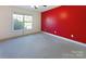 Carpeted bedroom with bright red accent wall, closet and sunlit window at 9530 Driftwood Ct, Hickory, NC 28601