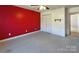 Bedroom with a red accent wall, carpet flooring, closet, and an adjacent room at 9530 Driftwood Ct, Hickory, NC 28601