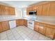 Well-maintained kitchen with white appliances, tile floor, and oak cabinetry at 9530 Driftwood Ct, Hickory, NC 28601