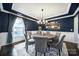 Dining room showcases dark blue walls, a round wooden table, and modern chandelier at 9762 Verdun Ct, Indian Land, SC 29707