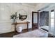 Bright foyer with wood floors, decorative trim, wooden console table and glass front door at 9762 Verdun Ct, Indian Land, SC 29707