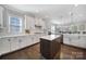 Well-lit kitchen with a large island, white cabinets, and modern appliances at 9762 Verdun Ct, Indian Land, SC 29707