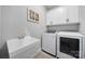 Laundry room with sink, modern washer and dryer, and overhead cabinets at 9762 Verdun Ct, Indian Land, SC 29707