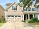 Charming two-story home featuring a decorative garage, black shutters, and a manicured front yard at 1007 Equipoise Dr, Indian Trail, NC 28079