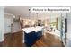 Open-concept kitchen features a center island, modern appliances, and seamless flow into the living and dining areas at 1010 Merganser Way, Indian Trail, NC 28079
