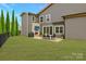 A spacious backyard features an outdoor dining area with stone fireplace, perfect for entertaining at 11327 James Coy Rd, Davidson, NC 28036