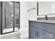Bathroom featuring patterned tile, floating vanity with stone countertop, and tiled shower with glass door at 11327 James Coy Rd, Davidson, NC 28036