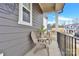 This cozy covered front porch features two gray chairs and a small table at 11327 James Coy Rd, Davidson, NC 28036