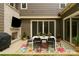 Stylish outdoor patio boasts a cozy dining setup, a built-in stone fireplace and inviting string lights at 11327 James Coy Rd, Davidson, NC 28036