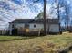 Backyard view of a light blue home featuring a wooden deck and well-maintained yard at 121 Deertrack Dr, Mount Holly, NC 28120