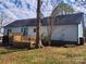 Backyard view of a light blue home featuring a wooden deck and well-maintained yard at 121 Deertrack Dr, Mount Holly, NC 28120