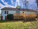 Backyard view of a light blue home featuring a wooden deck and well-maintained yard at 121 Deertrack Dr, Mount Holly, NC 28120