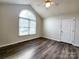 This bedroom features a vaulted ceiling, modern floors, and a large arched window at 121 Deertrack Dr, Mount Holly, NC 28120