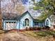View of a charming light-blue home with white garage door, arched window and well-kept lawn at 121 Deertrack Dr, Mount Holly, NC 28120