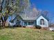 Charming blue single-story home featuring manicured front yard, flowerbeds and inviting front porch at 121 Deertrack Dr, Mount Holly, NC 28120