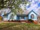 Charming blue single-story home featuring manicured front yard, flowerbeds and inviting front porch at 121 Deertrack Dr, Mount Holly, NC 28120