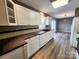 Bright kitchen with white cabinets, dark countertop, and modern laminate flooring at 121 Deertrack Dr, Mount Holly, NC 28120