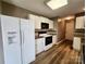Functional kitchen featuring white appliances, abundant storage, and modern laminate flooring at 121 Deertrack Dr, Mount Holly, NC 28120