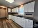 Well-lit kitchen with white cabinets, dark countertop, and tiled backsplash at 121 Deertrack Dr, Mount Holly, NC 28120