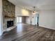 Open-concept living area with a stone fireplace, seamlessly connecting to other spaces and vinyl floors at 121 Deertrack Dr, Mount Holly, NC 28120