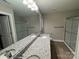 Bathroom featuring double sinks with granite countertops, framed mirror, and a glass-enclosed shower at 1309 Meadow Ave, Kannapolis, NC 28083