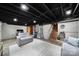 Finished basement features exposed ductwork, concrete walls, and gray seating at 1501 Laurel Ln, Gastonia, NC 28054
