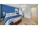 Well-lit bedroom with hardwood floors, blue accent wall, and stylish floor lamp at 1501 Laurel Ln, Gastonia, NC 28054