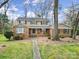 Charming two-story home with a brick facade and inviting front porch and manicured lawn and mature trees at 1501 Laurel Ln, Gastonia, NC 28054