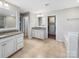 Large bathroom featuring double vanities, granite countertops, and neutral tile floors at 15827 Arabian Mews Ln, Charlotte, NC 28278