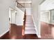 Bright foyer featuring hardwood floors, a staircase with carpeted steps and a wooden railing at 15827 Arabian Mews Ln, Charlotte, NC 28278