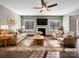 Bright living room featuring a fireplace, a ceiling fan, hardwood floors, and neutral decor at 15827 Arabian Mews Ln, Charlotte, NC 28278