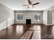 Bright living room featuring a fireplace, a ceiling fan, hardwood floors, and windows providing natural light at 15827 Arabian Mews Ln, Charlotte, NC 28278