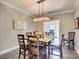 A modern dining room is illuminated by a unique chandelier and boasts stylish decor and comfortable seating for six at 1823 Rain Forest Dr, York, SC 29745