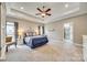 The bright main bedroom has a tray ceiling, carpeting, ceiling fan, en suite bath, and neutral-toned decor at 1823 Rain Forest Dr, York, SC 29745