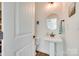 This is a view of the powder room that contains a white pedestal sink, decorative mirror, and hardwood floors at 1823 Rain Forest Dr, York, SC 29745