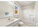 Bright bathroom featuring white vanity, a window, toilet, and a tub with shower at 207 Crossing Ave, Belmont, NC 28012