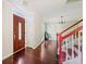 Bright foyer with hardwood floors, red accents on the staircase, and a glimpse of the home's interior design at 207 Crossing Ave, Belmont, NC 28012