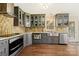 Updated kitchen with stainless appliances, tiled backsplash, and wood floors at 207 Crossing Ave, Belmont, NC 28012