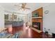 Open-concept living area with a brick fireplace, hardwood floors, and a view into the adjacent modern kitchen at 207 Crossing Ave, Belmont, NC 28012