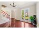 Living room area with hardwood floors, staircase, and ample natural light through large windows at 207 Crossing Ave, Belmont, NC 28012