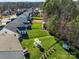 Aerial view of landscaped backyard featuring patio with seating and manicured lawn at 3181 Helmsley Ct, Concord, NC 28027