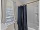 Bright bathroom features a tub and shower combination with a blue patterned shower curtain and natural light at 3181 Helmsley Ct, Concord, NC 28027
