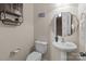Half bath featuring pedestal sink, shelving, updated lighting and convenient access to other areas at 3181 Helmsley Ct, Concord, NC 28027