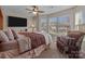 Bright bedroom with large windows, ceiling fan, and comfortable upholstered chair at 3181 Helmsley Ct, Concord, NC 28027