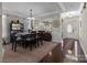 Elegant dining area with dark wood table, chair set and open access to living room at 3181 Helmsley Ct, Concord, NC 28027