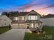Charming two-story home with a welcoming front porch, two-car garage, and vibrant landscaping at 3181 Helmsley Ct, Concord, NC 28027
